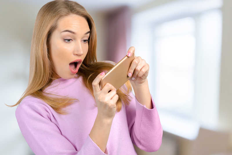 女人惊讶的使用智能手机