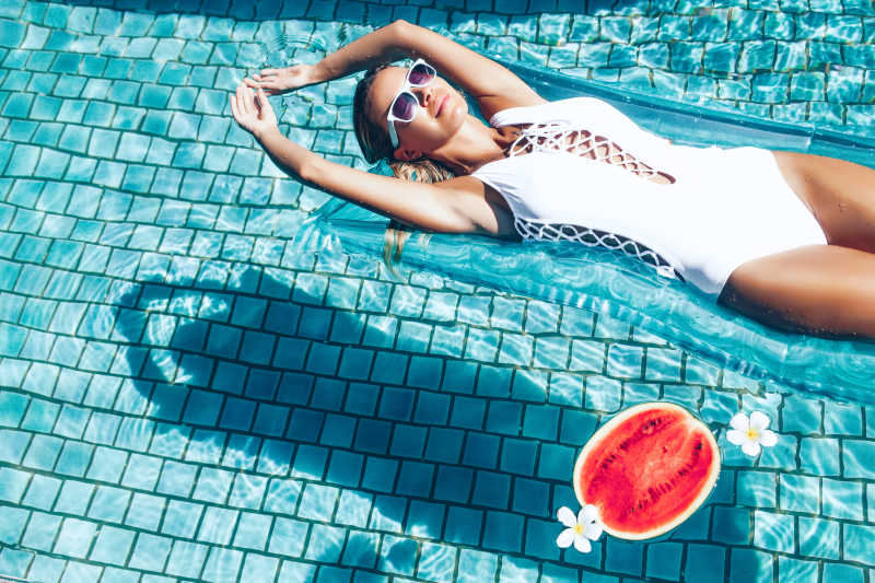 游泳池里躺着休息的美女和西瓜