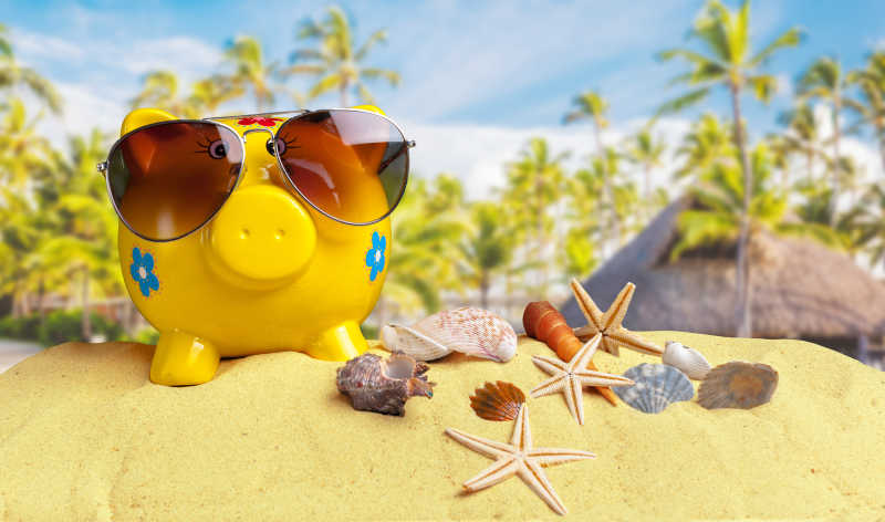 夏季储钱罐戴墨镜在海滩上