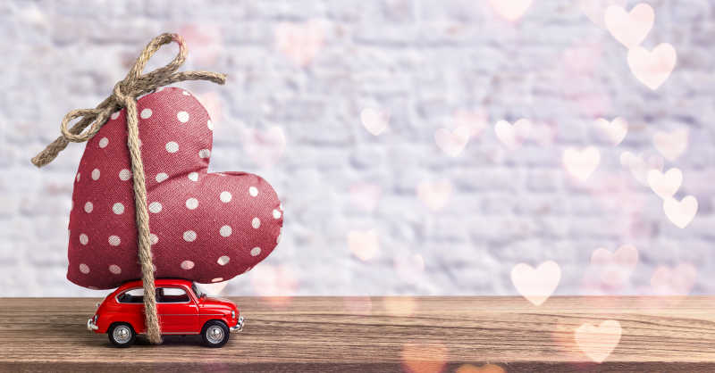 红色玩具汽车载着一颗爱心