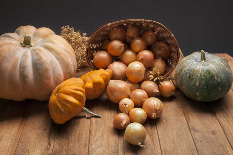木桌上的秋南瓜和洋葱