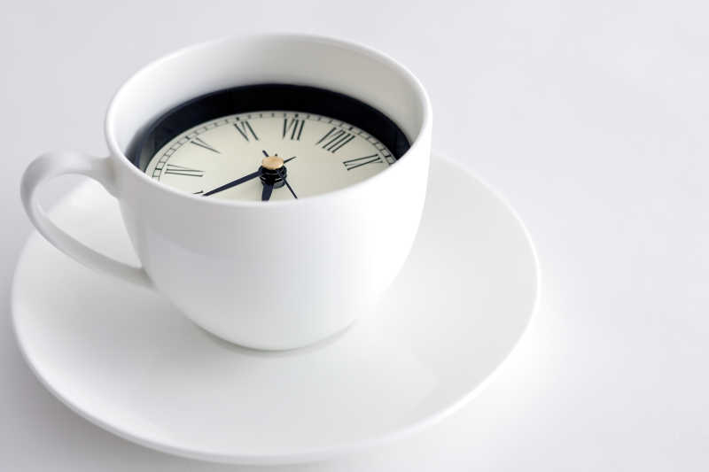 白色咖啡杯和里面的时钟