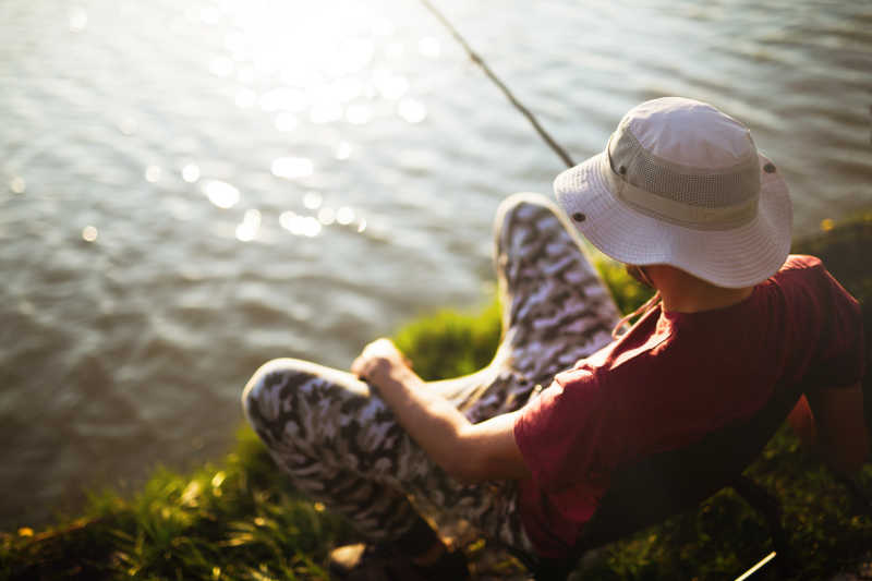 阳光下等待鱼儿上钩的钓鱼爱好者