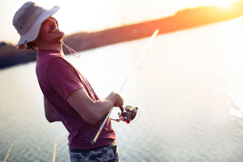 日落下正在钓鱼的钓鱼爱好者