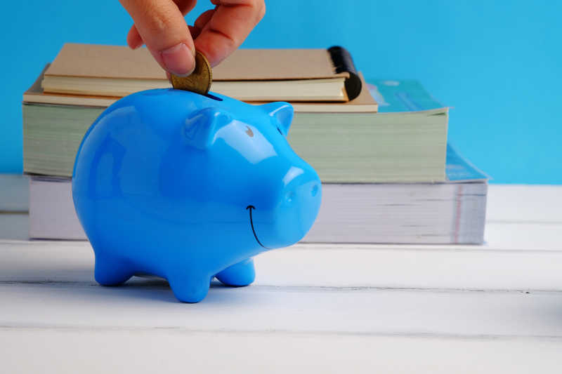 把货币放入蓝色存钱罐