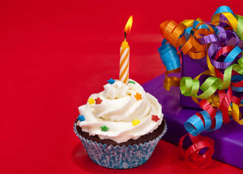 红色背景下的纸杯蛋糕和丝带