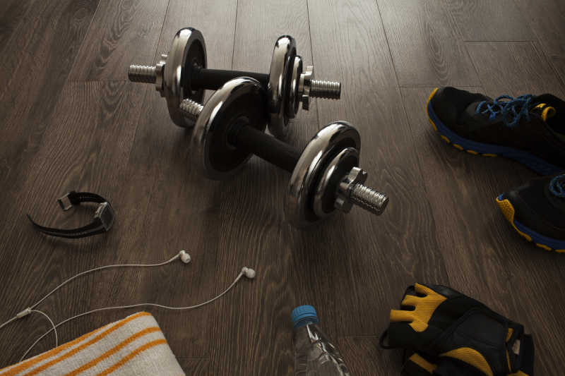 木板上的健身器材哑铃运动鞋和耳机