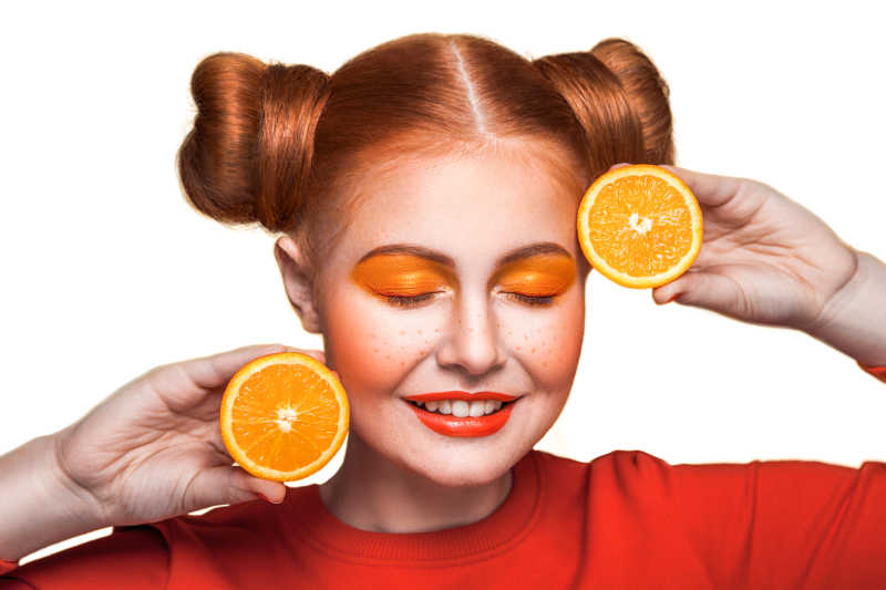 手拿橙子的闭眼美妆少女