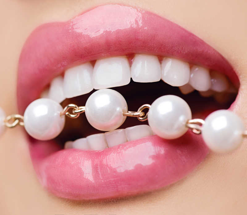 洁白的牙齿咬着珍珠