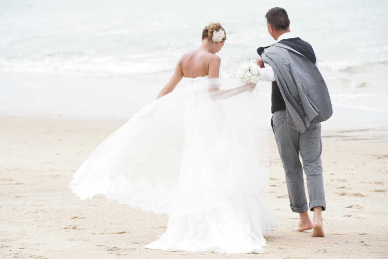 幸福快乐的新郎新娘在沙滩上散步