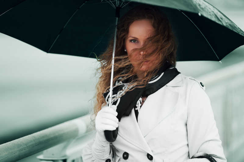 手拿伞站立在雨中的女人