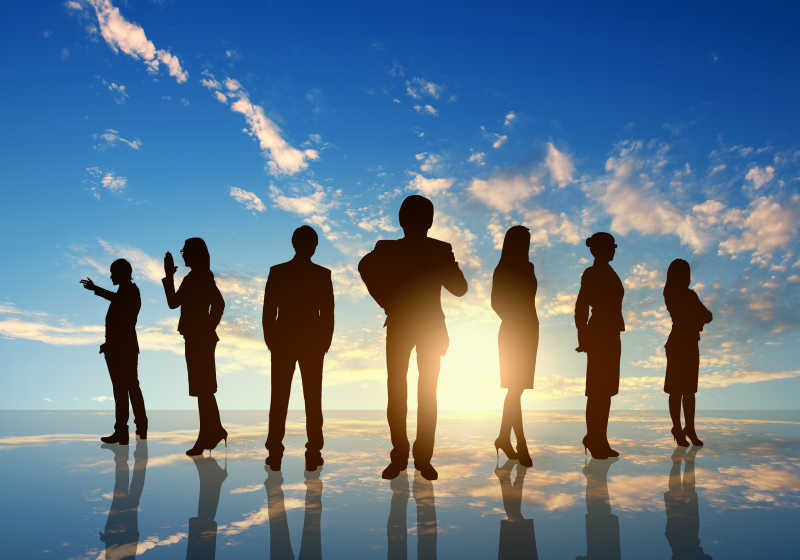 蓝天白云下的站立的业务团队