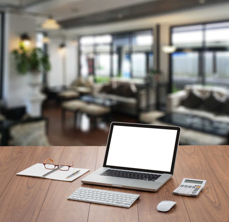 带模糊咖啡店背景的空白屏幕笔记本电脑