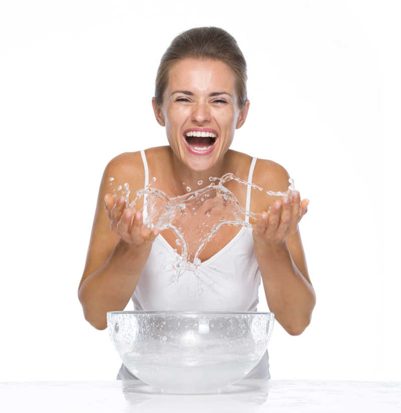 洗脸时溅起水花的快乐美女