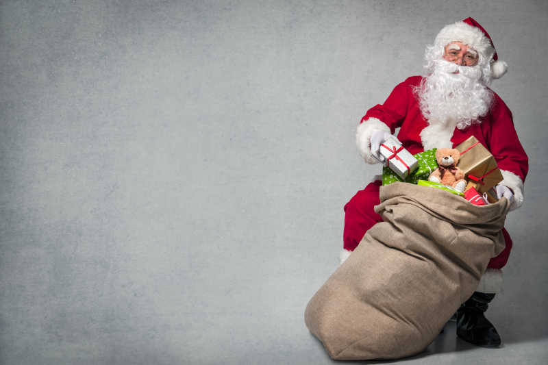 圣诞老人提着一个装满礼物的麻袋