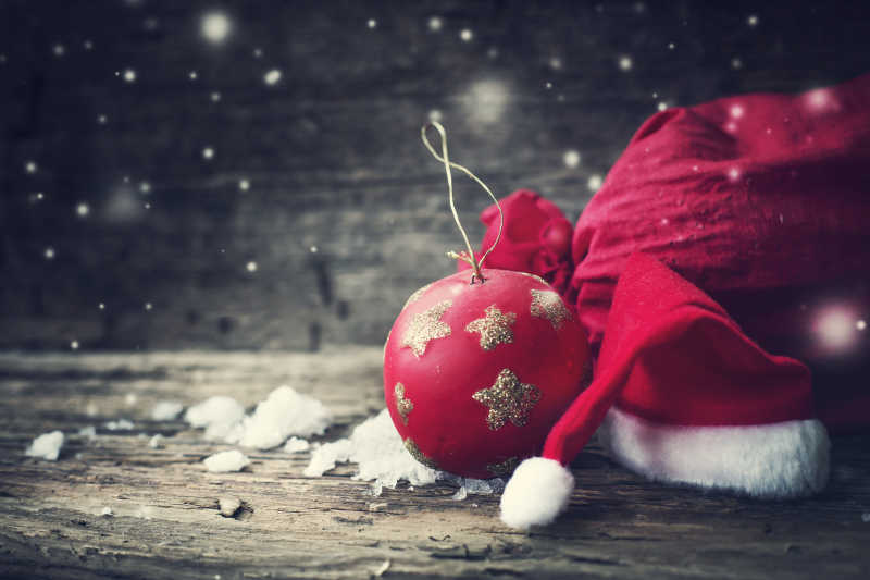 圣诞球圣诞红帽和雪花在木制背景上
