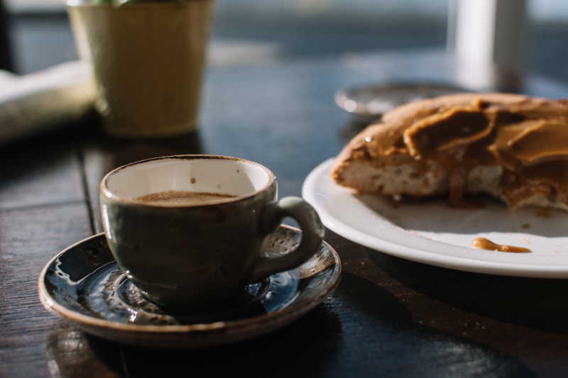 咖啡杯里的咖啡和盘子里的甜点特写