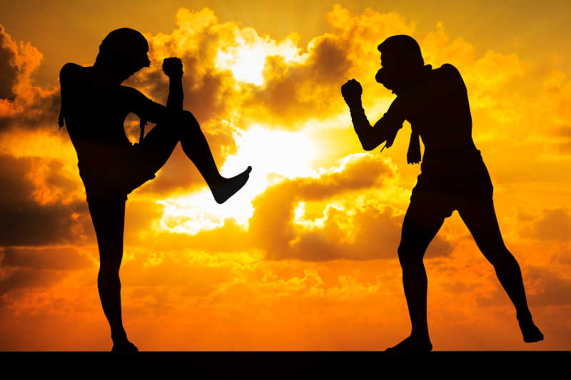 夕阳下的两个泰国拳击手正在对击练习