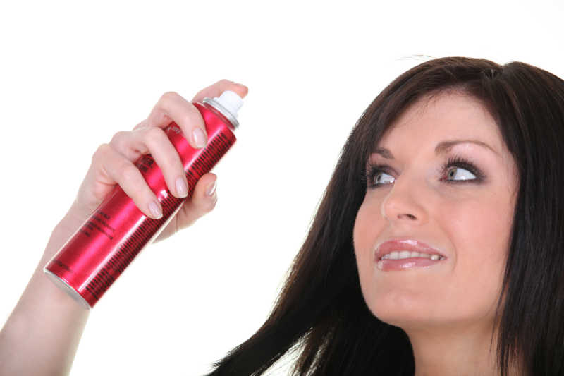 一个使用头发喷剂的女人特写