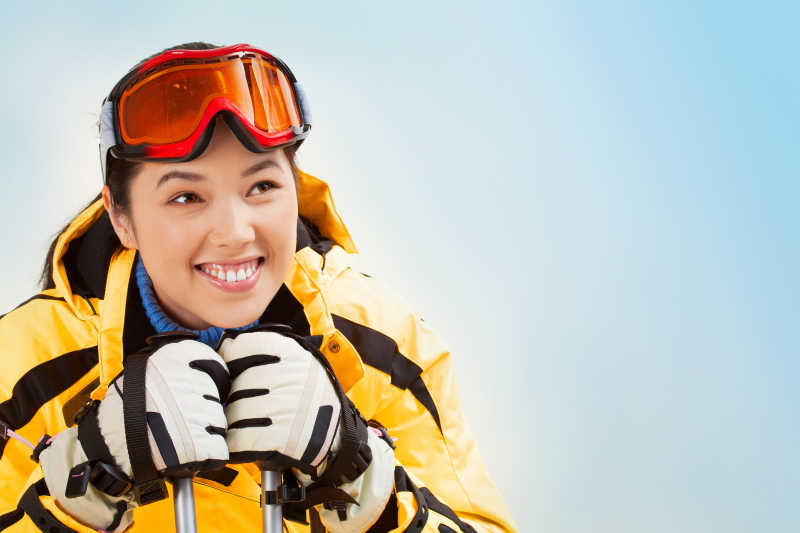 雪地里戴着运动眼镜的微笑女孩