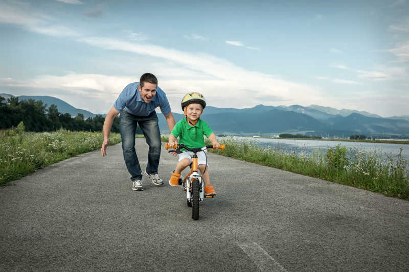 幸福爸爸教儿子在室外骑自行车