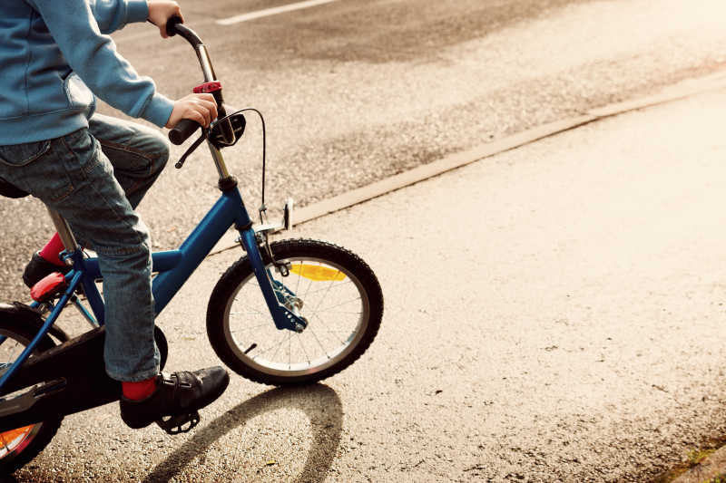 孩子骑自行车在柏油路上