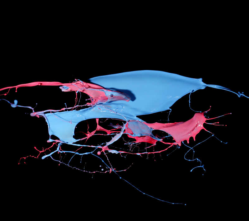 蓝色和红色油漆飞溅在黑色背景上