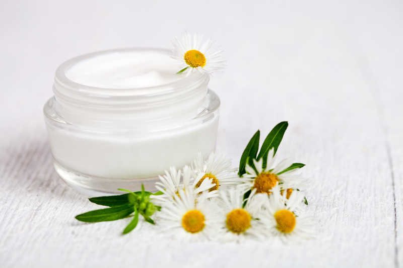 白色木制背景下的护肤品面霜特写