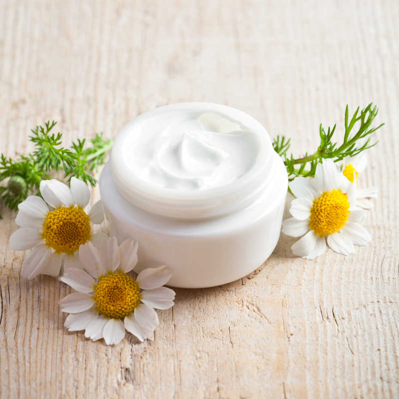 浅棕色木制背景上的面霜特写