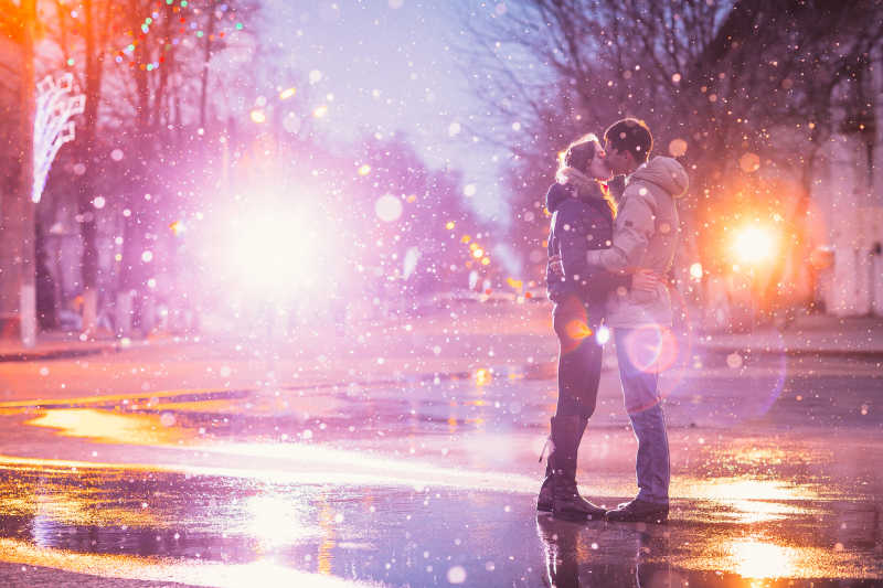 热恋中的情侣在城市街道雪地里接吻