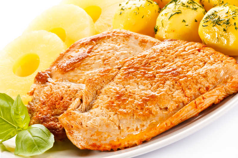 盘子里的炸鸡腿煮土豆球特写