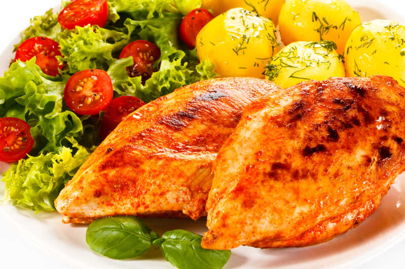 炸鸡腿土豆球和蔬菜配菜特写