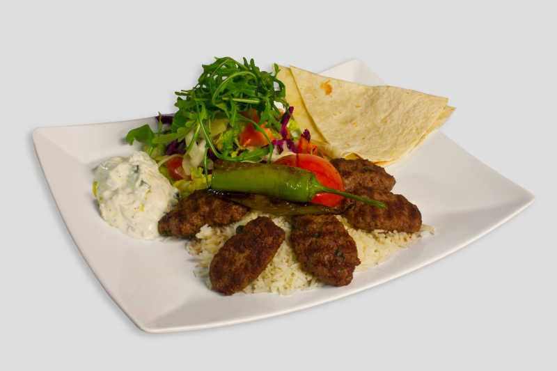 白色盘子里的米饭肉块和蔬菜