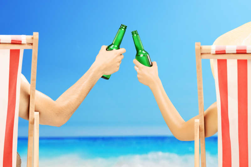 沙滩椅上喝啤酒的男人和女人
