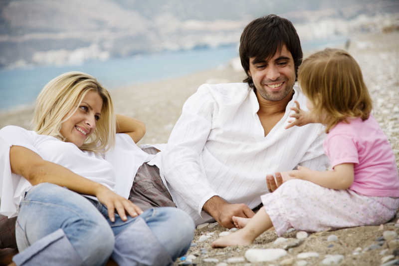 在沙滩上享受美好时光的年轻家庭