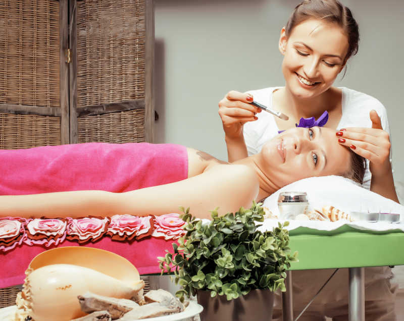 漂亮医生微笑照顾得到水疗治疗的迷人女士