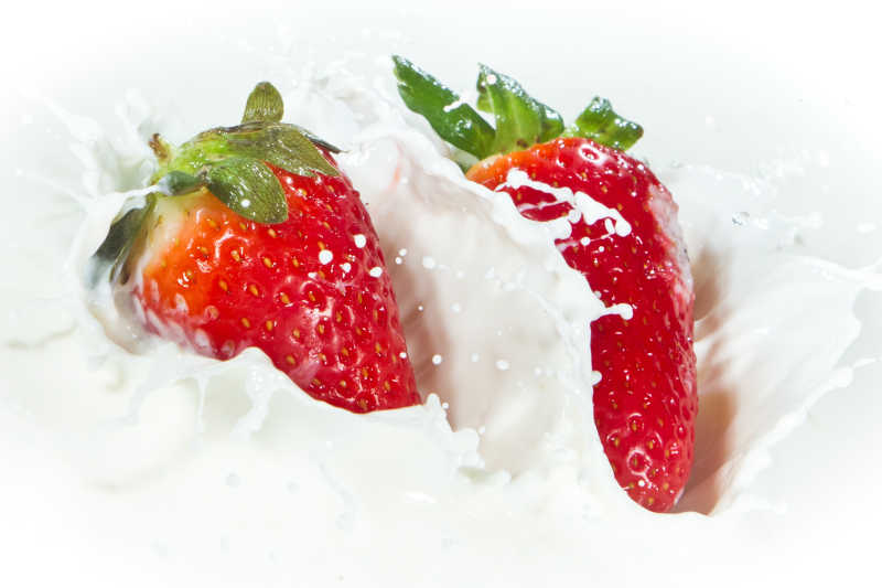 美味的草莓掉进溅牛奶里特写