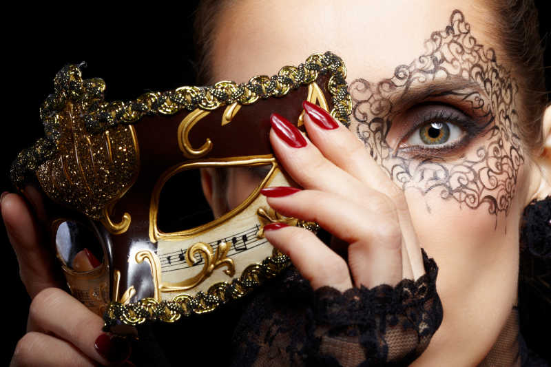 美丽的年轻女子戴着神秘的黄金威尼斯面具