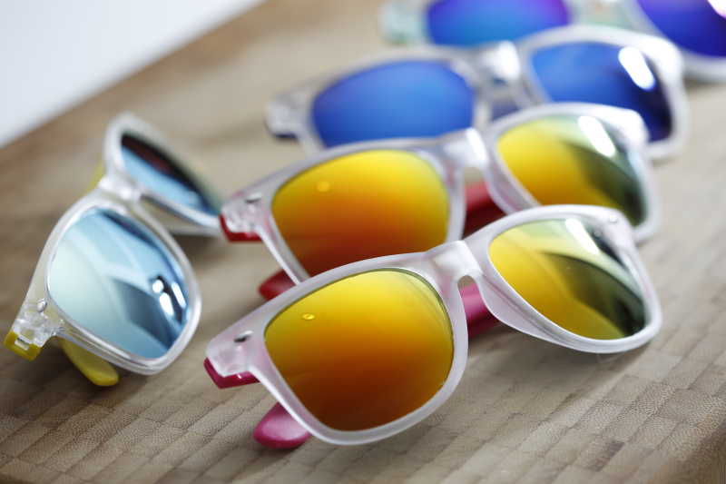 木制桌子上放着太阳墨镜