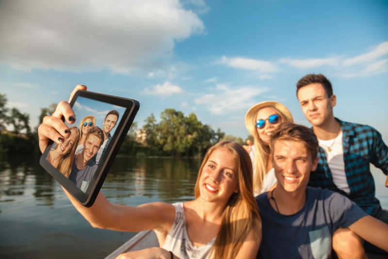 年轻的男女朋友们在船上自拍