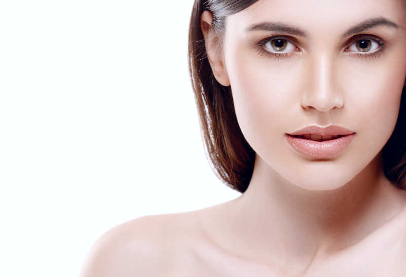 美丽的女人用性感的嘴唇面对着白色的工作室特写