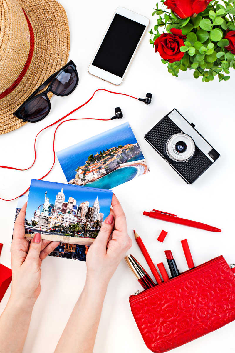 女性手拿明信片和日常化妆配件