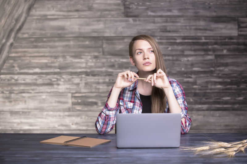 年轻女子手拿铅笔正在冥思