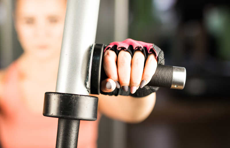 年轻女子在健身机上伸展肌肉