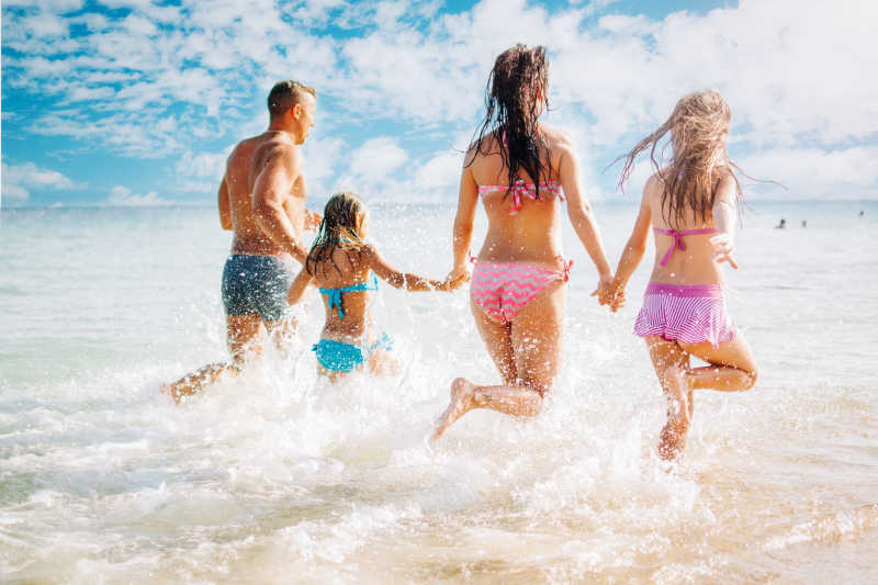 在海滩上玩得开心的幸福家庭