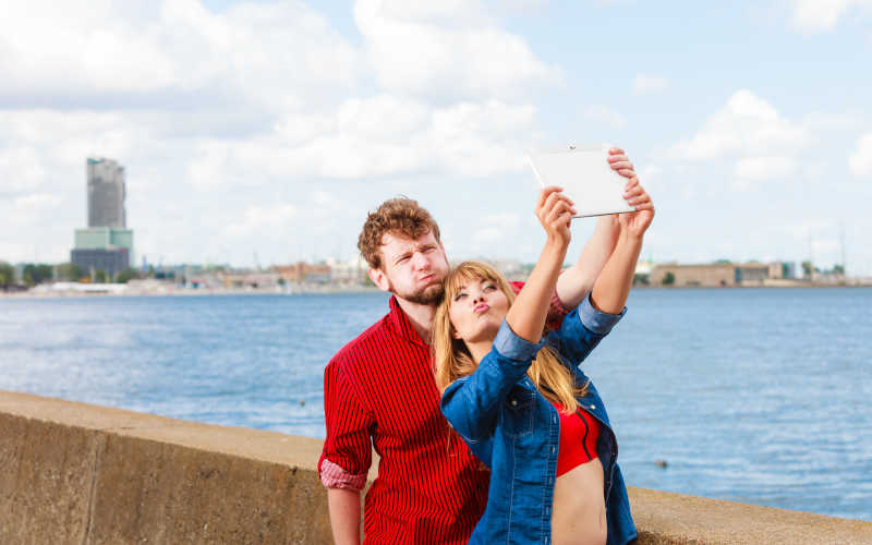 年轻夫妇用平板自拍