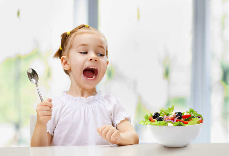 可爱的金发女孩吃水果