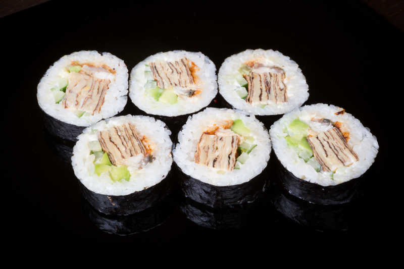黑色背景下的美味寿司卷