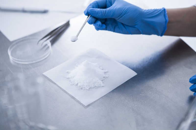 药物开发人员用勺子舀一勺药粉