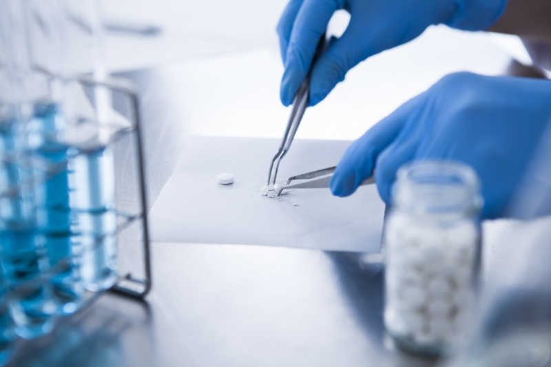 药物开发人员用镊子捣碎药片